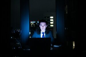 homme utilisant un ordinateur dans une pièce sombre