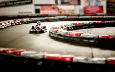 Un kart miniature tourne rapidement sur une piste indoor sinueuse