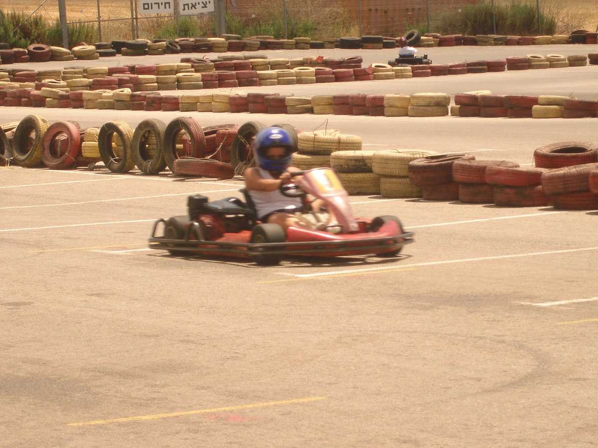Un pilote en kart rouge conduit sur une piste de karting Un pilote en kart rouge conduit sur une piste de karting