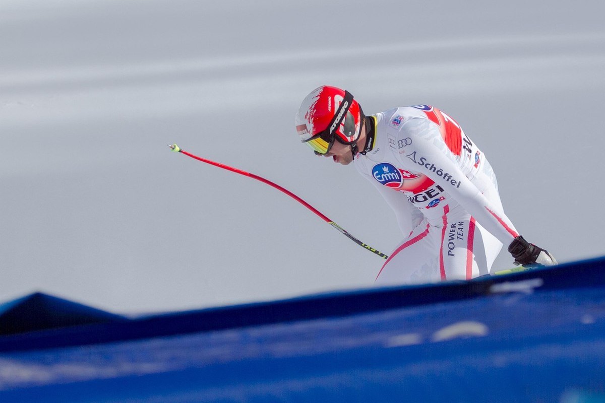 Un pilote en combinaison de ski prêt à monter dans un kart sur la neige Un pilote en combinaison de ski prêt à monter dans un kart sur la neige