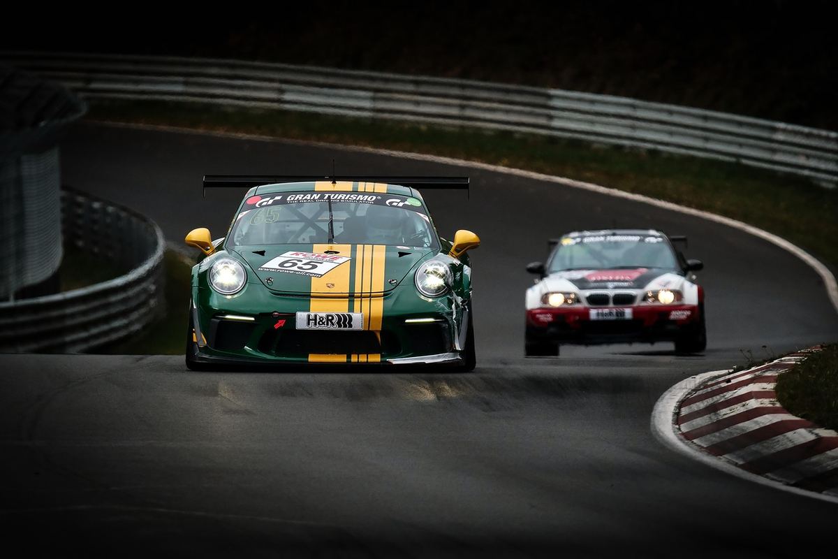 Deux voitures de sport s'affrontent sur un virage de circuit Deux voitures de sport s'affrontent sur un virage de circuit
